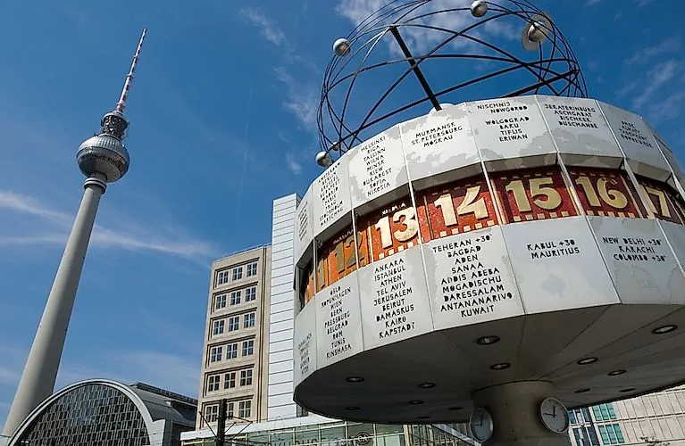 Weltzeituhr auf dem Berliner Alexanderplatz bei Tageslicht mit dem Fernsehturm im Hintergrund