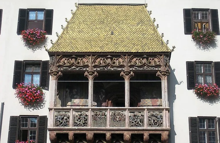 Das Goldene Dachl in Innsbruck mit verzierten Balkonen und roten Blumen an der Fassade.