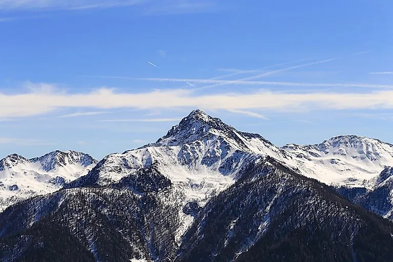 Die schneebedeckte Ultner Hochwart erhebt sich über die verschneiten Wälder des Ultentals