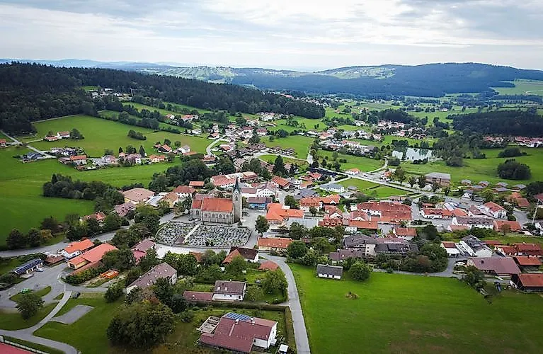 Letný pohľad na Neuschönau v Bavorskom lese s výhľadom na zelené kopce a tradičné strechy
