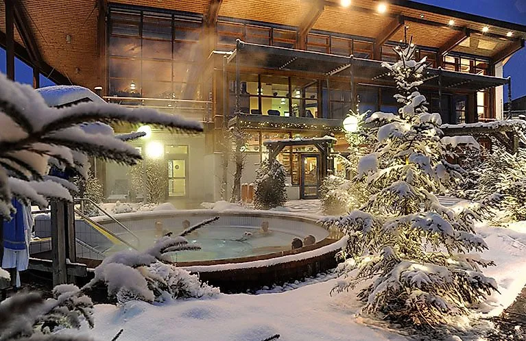 Entspannte Gäste im warmen Außenbecken der Obermain Therme, umgeben von verschneiter Winterlandschaft.