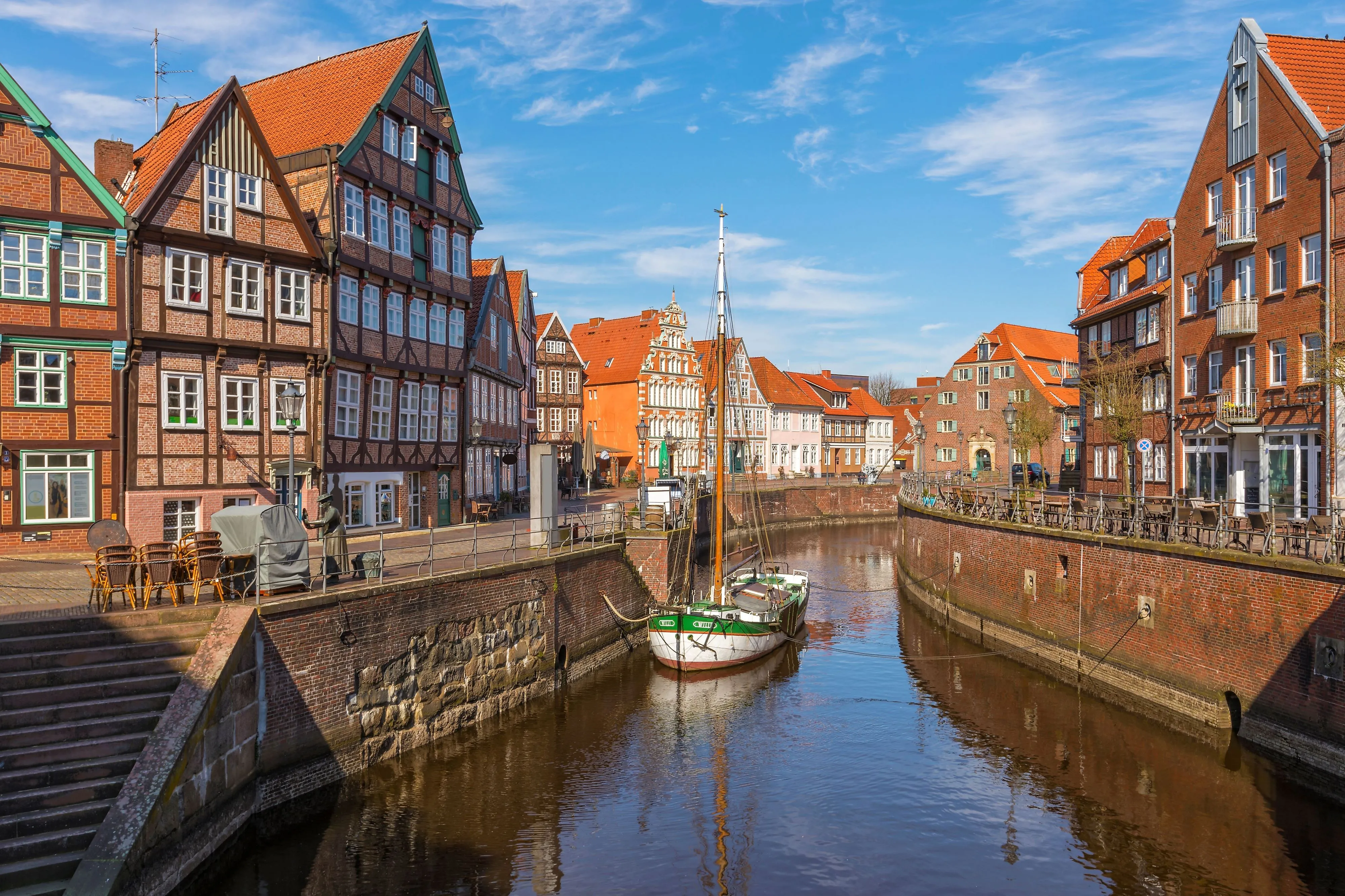 Historische Fachwerkhäuser am Alten Hafen in Stade mit Segelboot im Wasser