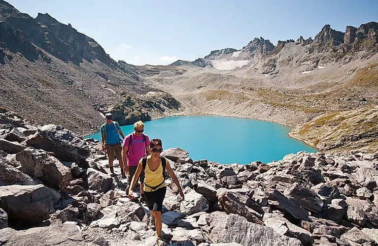 Wanderer am türkisblauen Bergsee bei Bad Ragaz – Sommeridylle in den Alpen mit Blick auf die umliegenden Gipfel