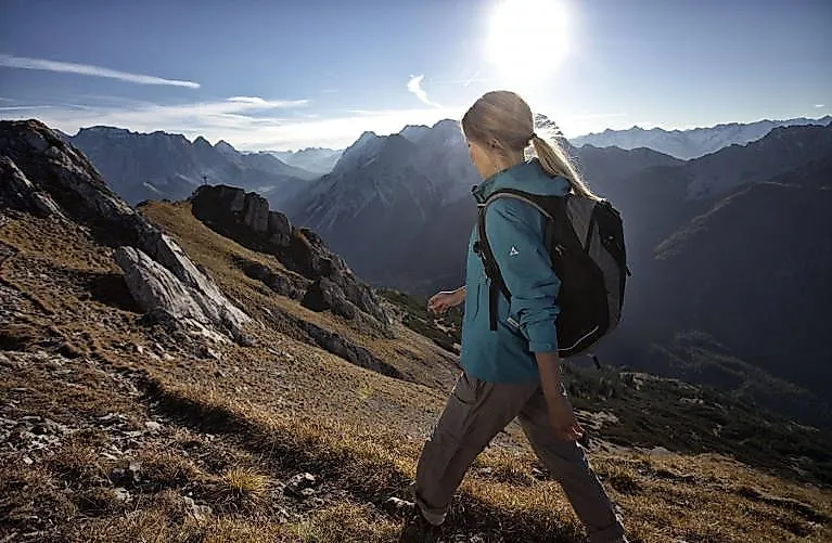 Wanderin mit Rucksack auf Bergpfad bei Sonnenuntergang in Biberwier in der Tiroler Zugspitz Arena