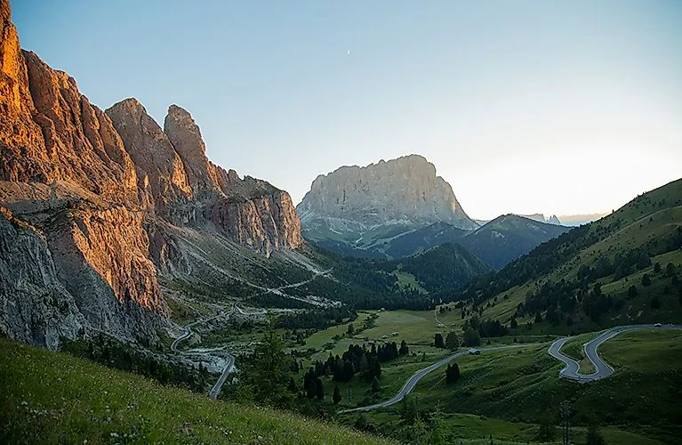 Sonnenuntergang über den Dolomiten bei St. Christina mit Serpentinen und grünem Tal.