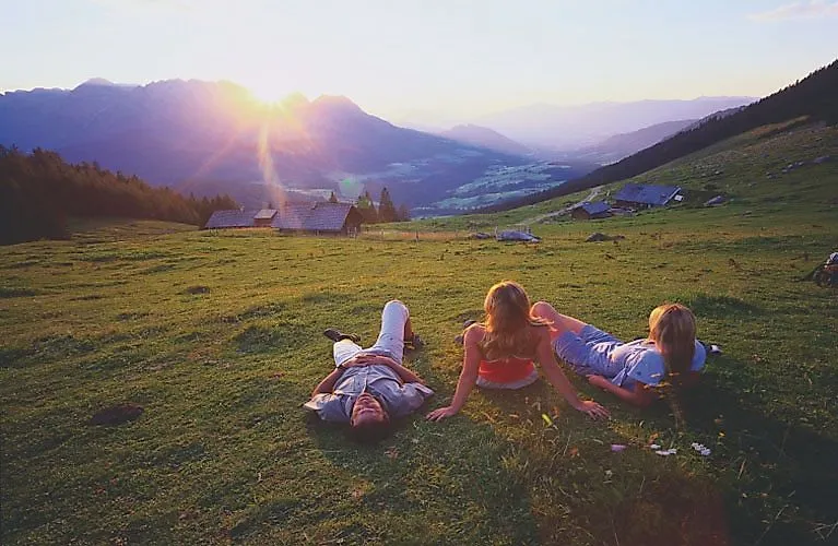Drei Wanderer genießen die Abendsonne über den Bergen bei Zell am See