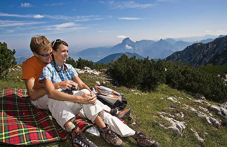 Ein Paar macht Pause beim Wandern auf einer Decke mit Blick auf das Gebirge bei Ebensee am Feuerkogel.