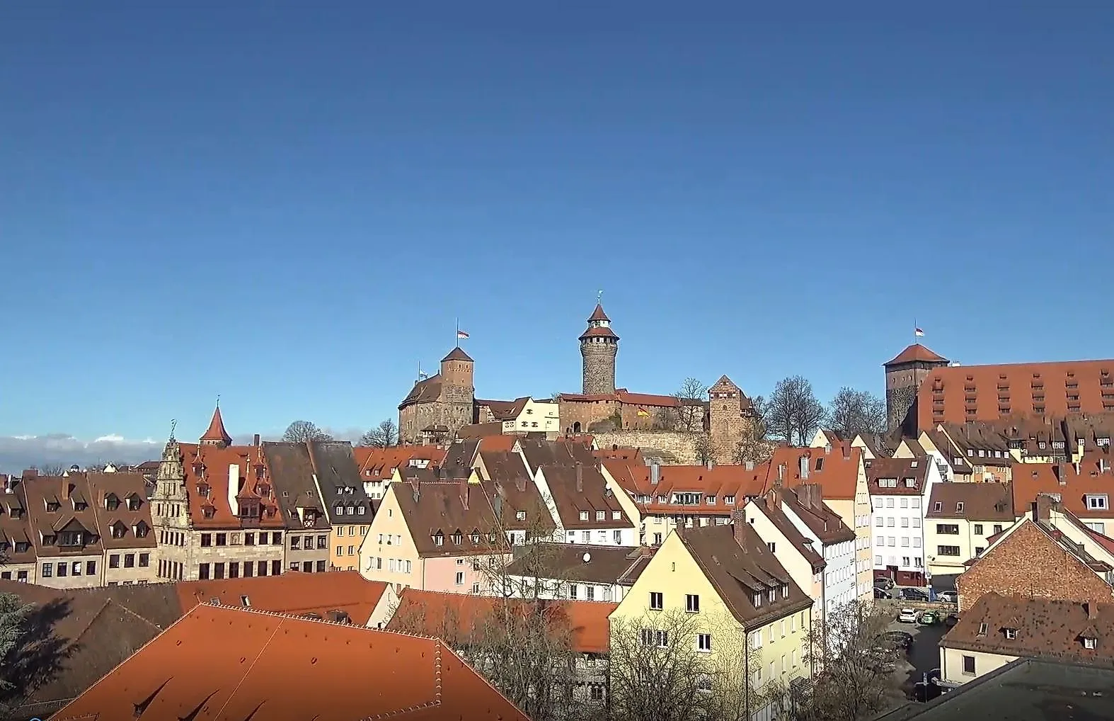 Blick auf die Nürnberger Altstadt mit der Kaiserburg im Hintergrund unter blauem Himmel.