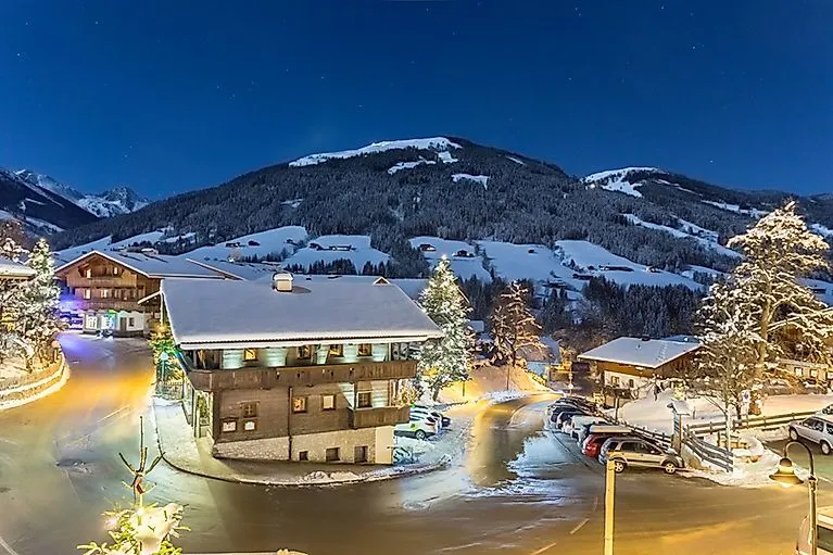 Brandenberg in Tirol im Winter bei Nacht mit verschneiten Häusern und beleuchteten Straßen, umgeben von Bergen