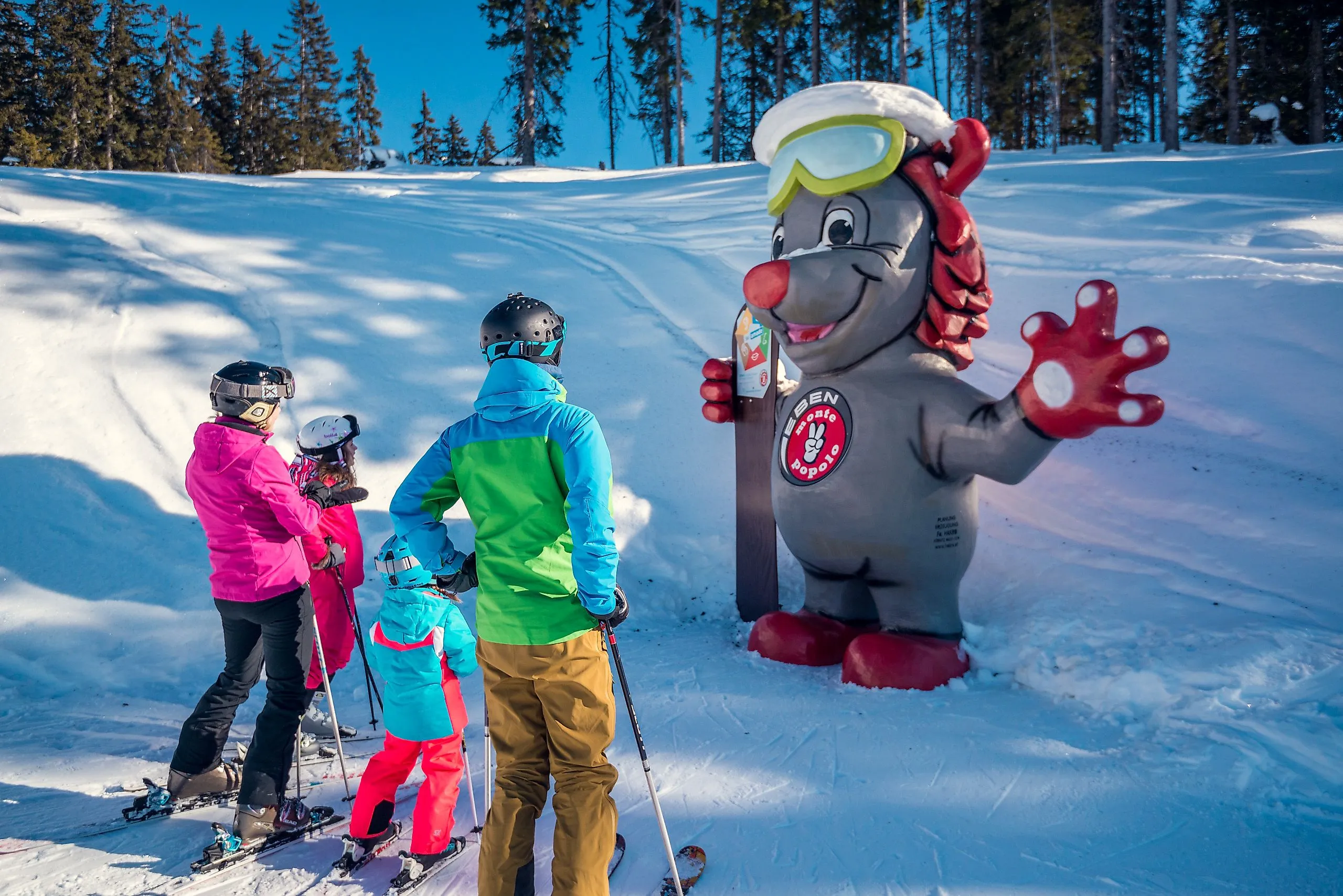 Kinder beim Skifahren im Skigebiet Monte Popolo in Eben im Pongau mit Erwachsenem in sonniger Winterlandschaft