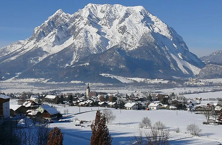 Winterliches Bergpanorama mit dem schneebedeckten Grimming und dem Ort am Fuße des Dachsteins.