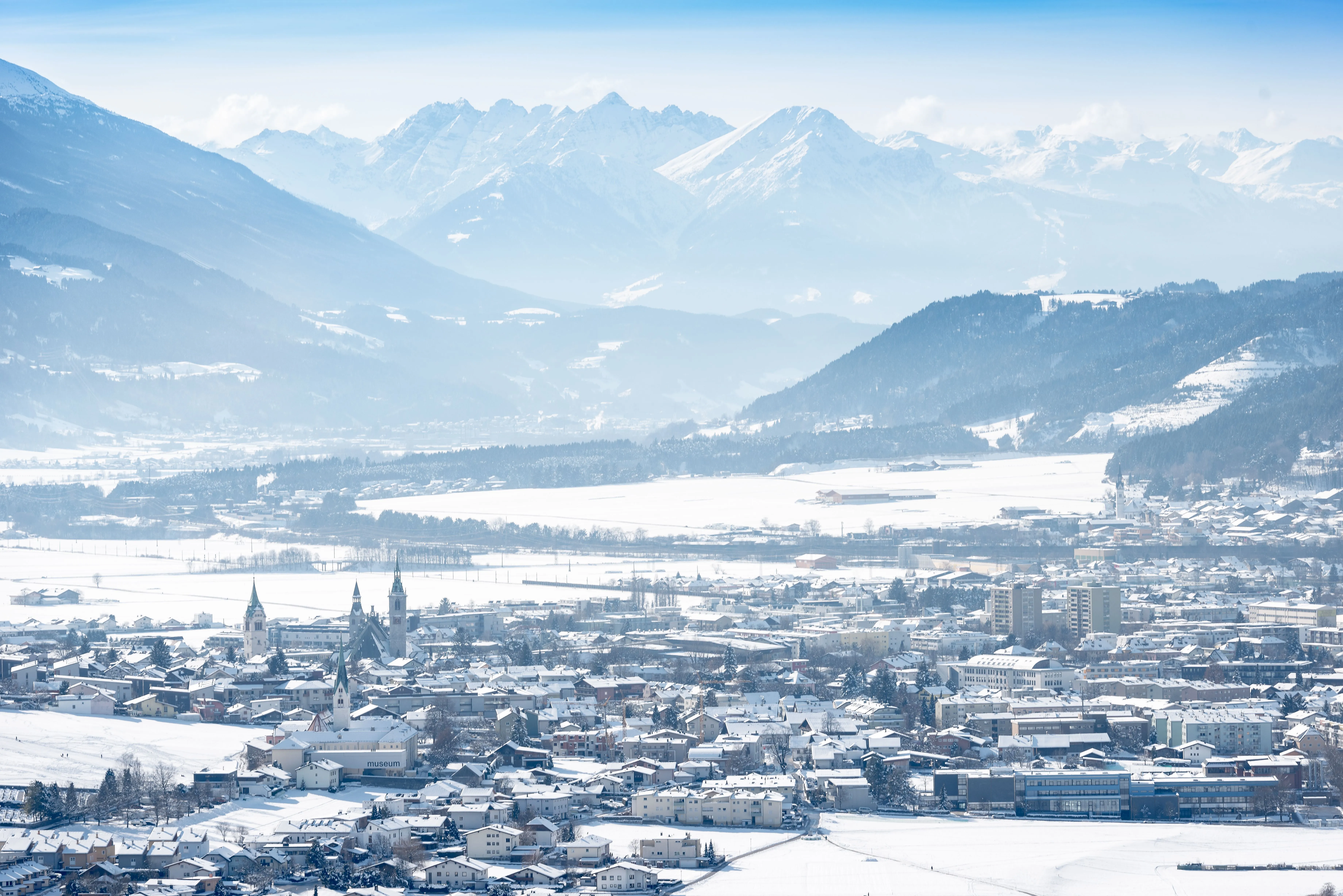 Winterlicher Blick auf Schwaz in Tirol mit verschneiter Stadt und Alpenpanorama im Hintergrund