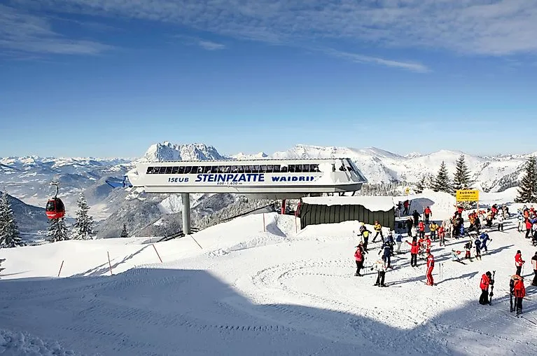 Skifahrer an der Gondelstation Steinplatte Waidring im Winter bei Sonnenschein