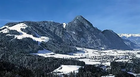 Verschneite Winterlandschaft mit Blick auf Reith im Alpbachtal und die umliegenden Berge in Tirol.