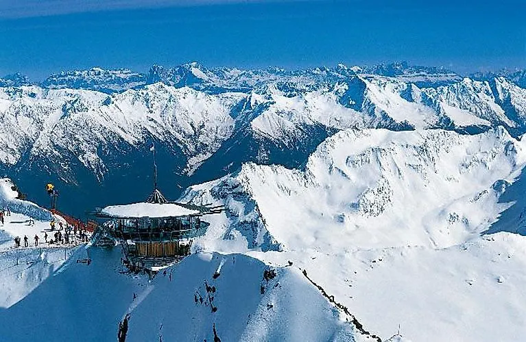Skifahrer bei einem Aussichtspunkt auf dem Gipfel von Hochgurgl mit beeindruckender Winterlandschaft im Hintergrund.