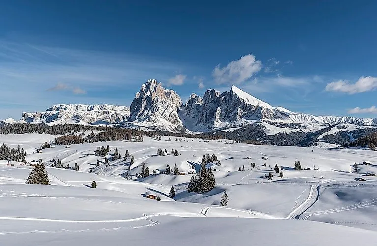 Verschneite Winterlandschaft der Seiser Alm mit Panorama auf die Dolomiten bei Sonnenschein