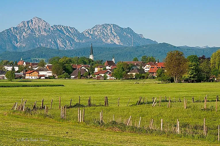 Sommerlandschaft in Anger mit Blick auf den Ort, Kirche und Gebirge im Hintergrund