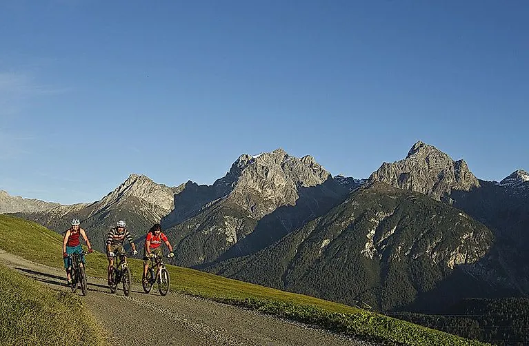 Mountainbiker auf Panoramaweg mit Bergkulisse bei Scuol in Graubünden