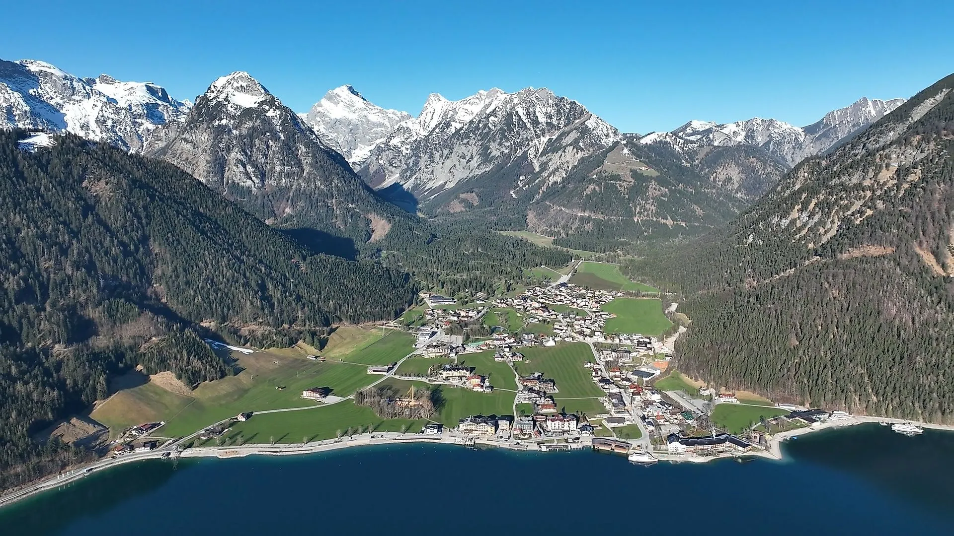 Luftaufnahme von Pertisau mit Blick auf den Achensee und die schneebedeckten Berggipfel