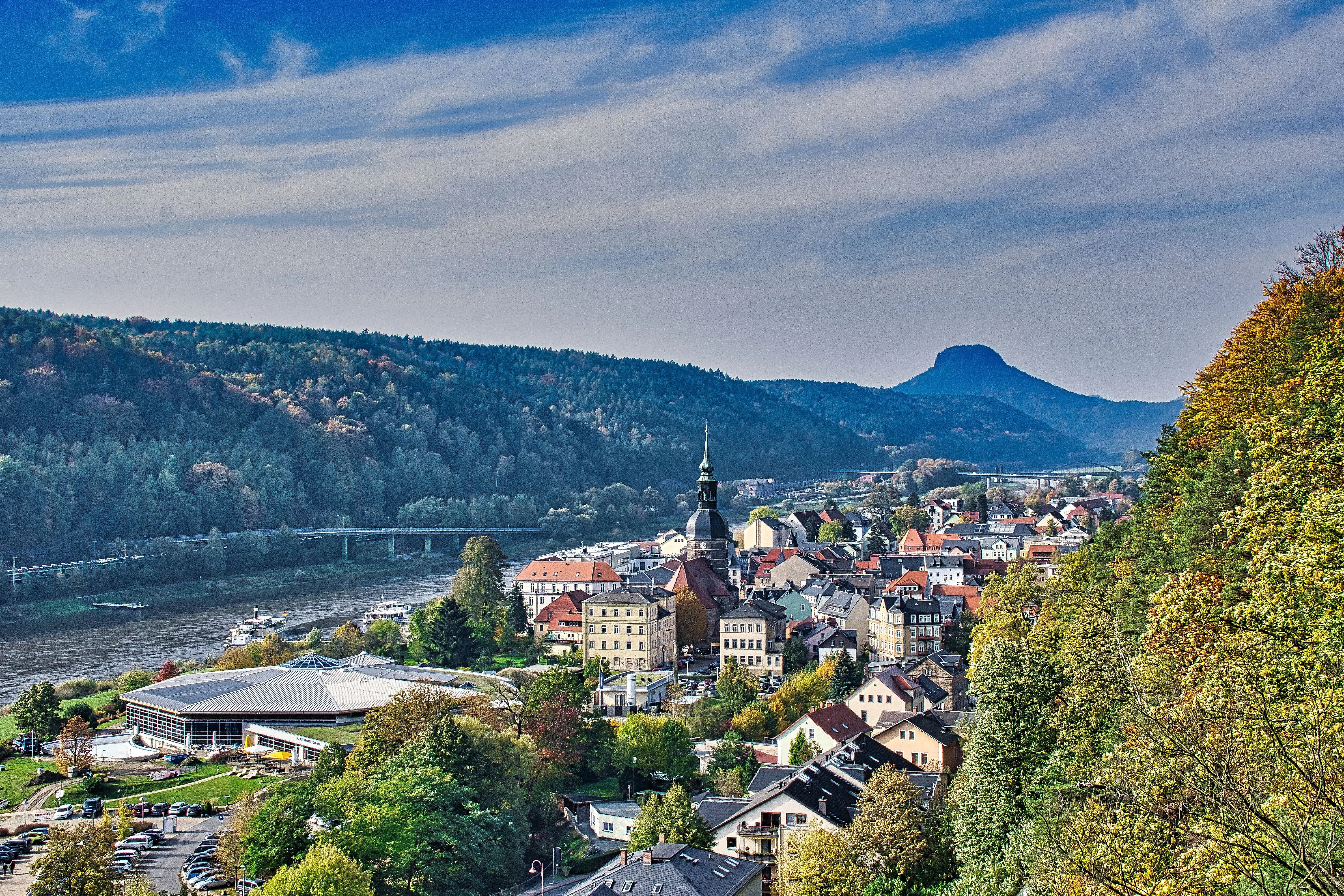 Sommerliches Stadtpanorama von Bad Schandau an der Elbe, umgeben von bewaldeten Hügeln und mit Blick auf den Lilienstein.