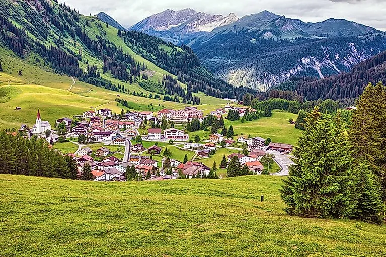Vue d'été de Berwang avec son architecture tyrolienne traditionnelle au milieu de prairies alpines verdoyantes et encadrées par des versants de montagne boisés.