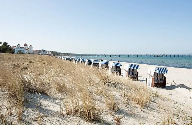Strandkörbe am Sandstrand von Binz auf Rügen mit Blick auf die Ostsee, Seebrücke und Dünen im Vordergrund