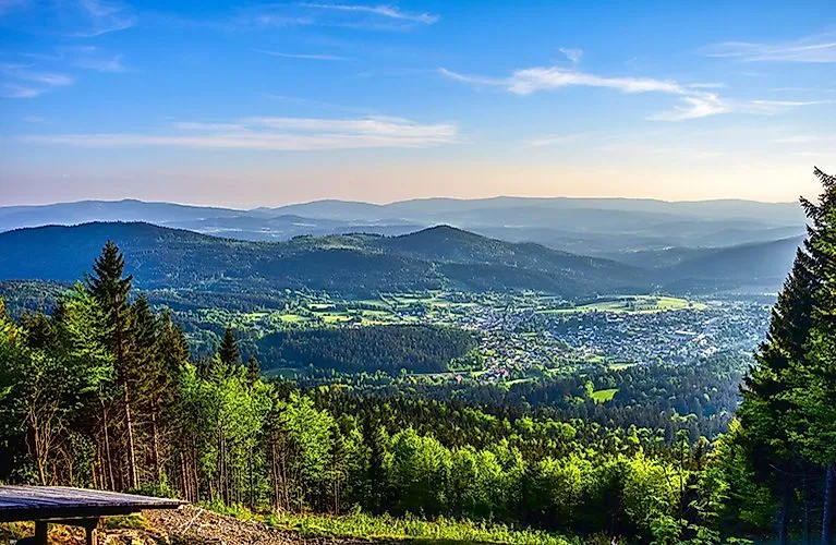 Weitblick auf die grüne Landschaft rund um Bodenmais im Sommer, eingebettet in die hügelige Waldlandschaft des Bayerischen Waldes.
