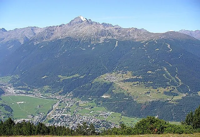 Sommerpanorama von Bormio mit grünen Bergen und Blick auf das Tal unter klarem Himmel
