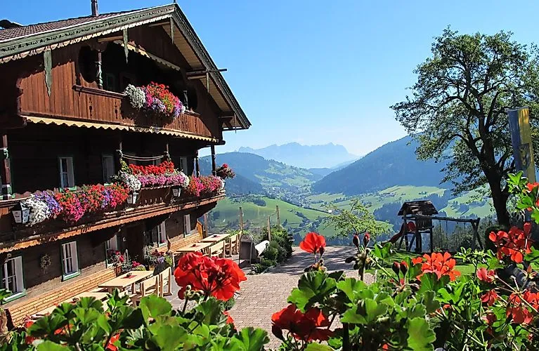 Traditionelles Bauernhaus mit Blumenschmuck in der Wildschönau mit Blick ins sonnige Tal