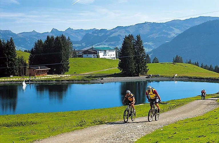 Ciclisti su un percorso estivo con vista sulle montagne e su un lago vicino a Ellmau, nella regione del Wilder Kaiser.