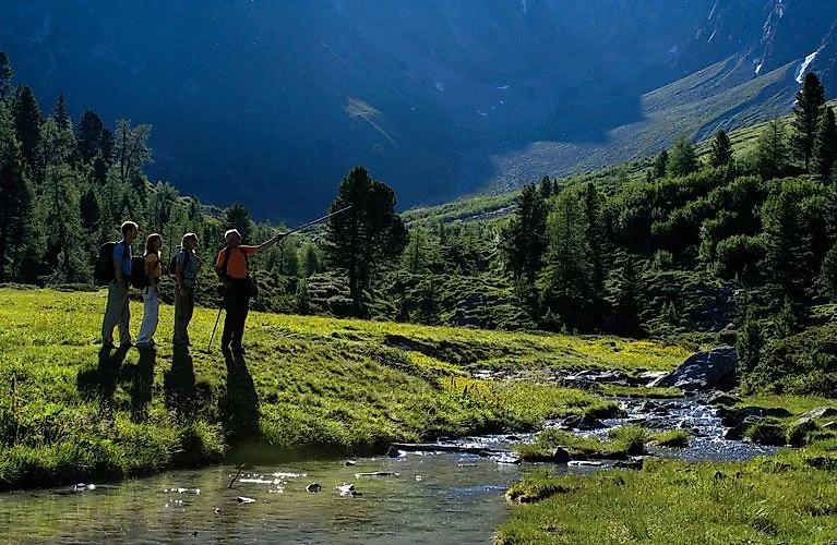 Wandergruppe erkundet das grüne Hochtal bei Fendels mit Blick auf Bach und Berge