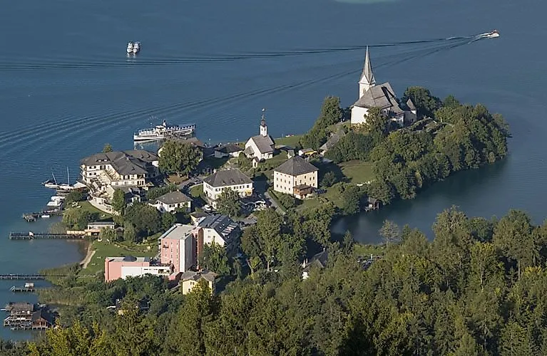 Idyllische Halbinsel mit Kirche am Kärntner See, umgeben von Natur