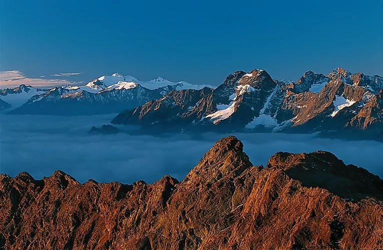 L'alba sulla catena montuosa di Sölden con una vista impressionante di cime innevate e un mare di nuvole.