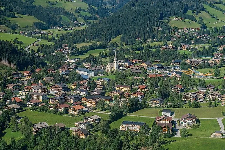 Sommerliches Panorama von Wagrain mit Blick über das malerische Dorf und grüne Almwiesen inmitten der Salzburger Bergwelt.