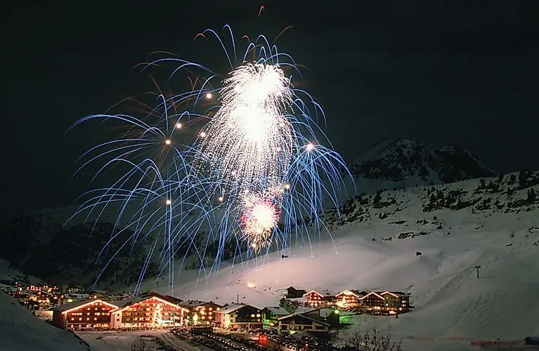 Buntes Feuerwerk über dem verschneiten Zürs am Arlberg bei Nacht
